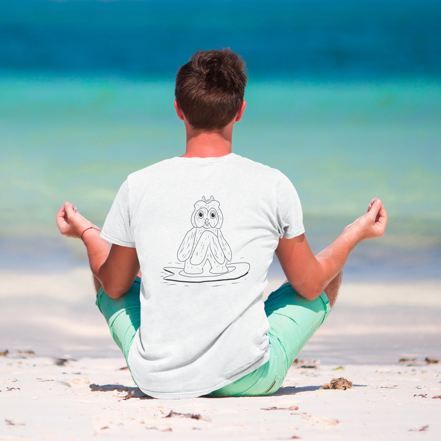 Surfing Owl Line | 100% Organic Cotton T Shirt worn by a man on the beach