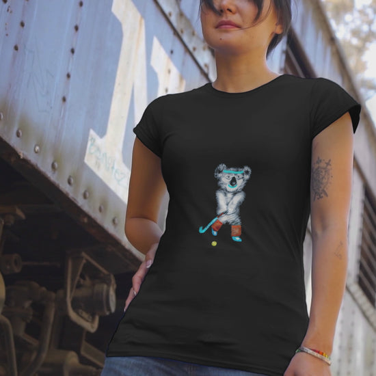 Koala playing hockey | Women's 100% Organic Cotton T Shirt worn by a woman by a train