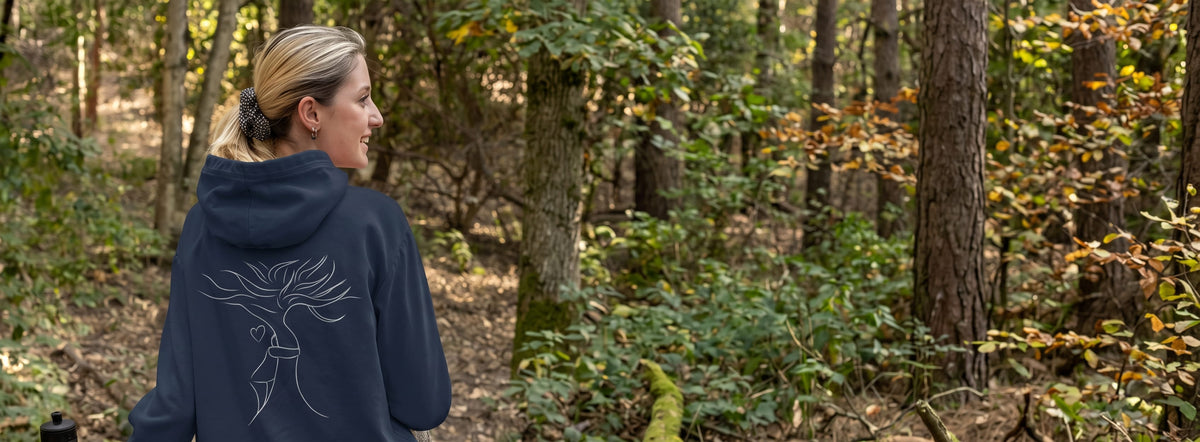 Woman wearing an organic hoodie in the woods