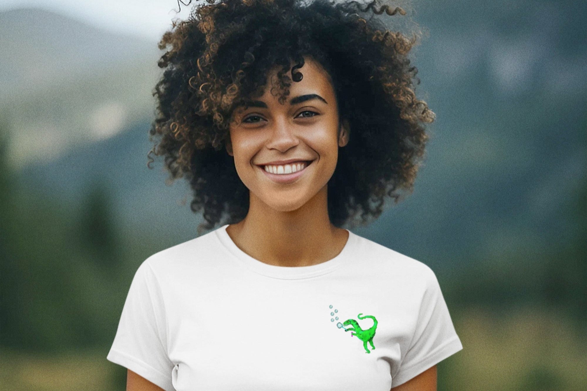 Person wearing a white t-shirt with a logo in a mountainous landscape