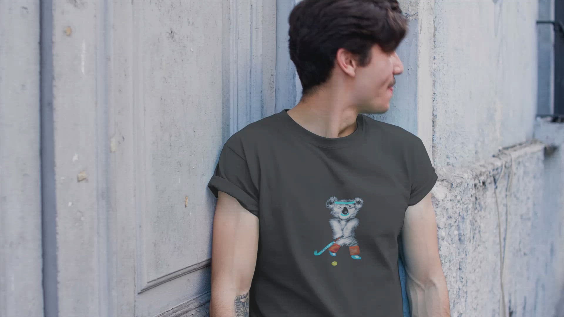Koala Playing Hockey | 100% Organic Cotton T Shirt worn by a man outside a house