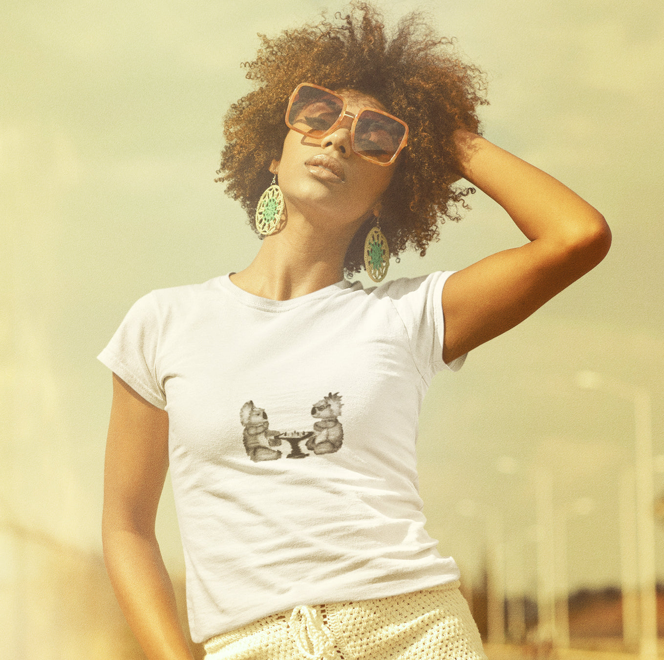 Koalas playing chess | Women's 100% Organic Cotton T Shirt worn by a woman with sunglasses
