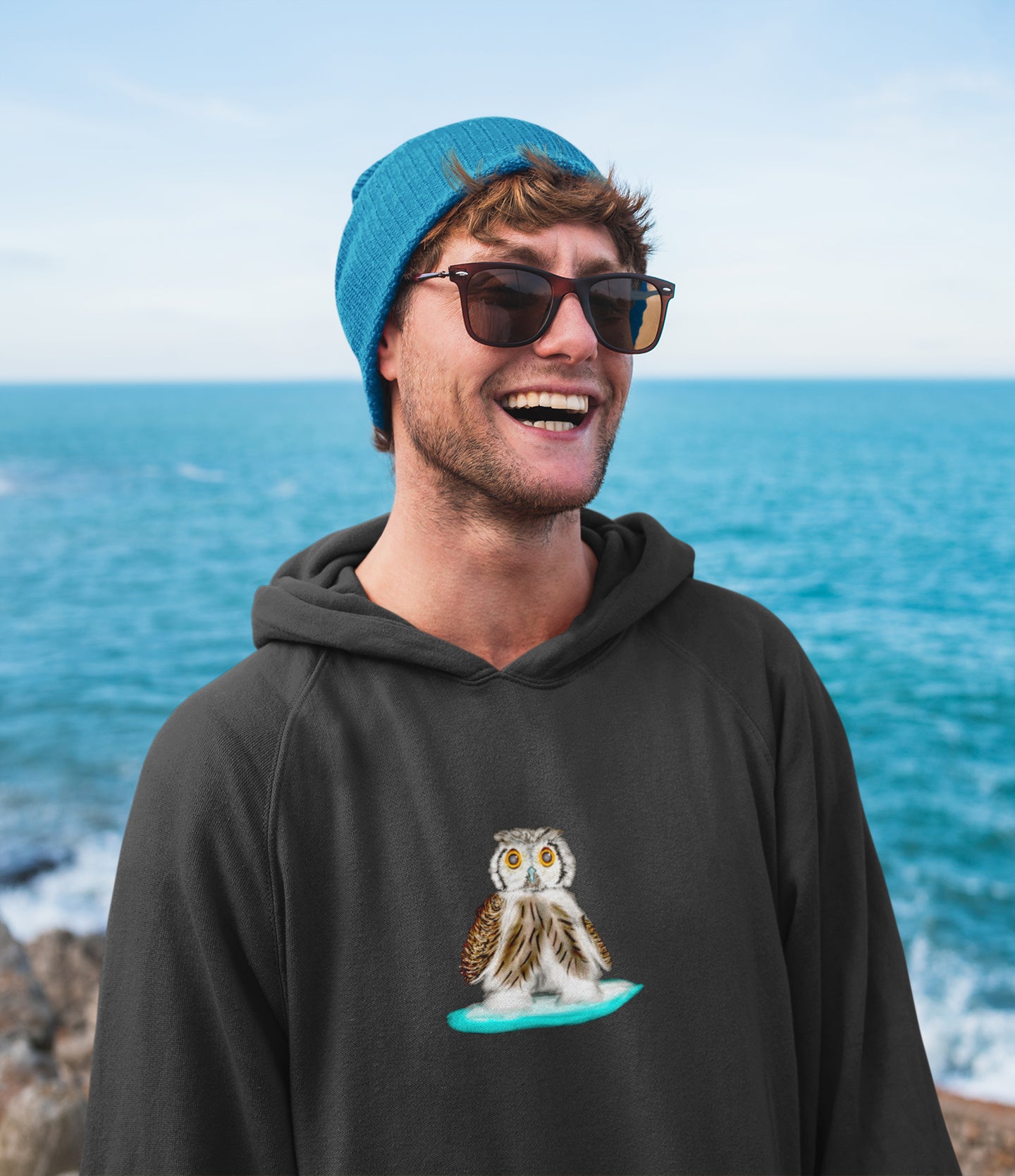 Man wearing a Owl on a surfboard sustainable vegan hoodie
