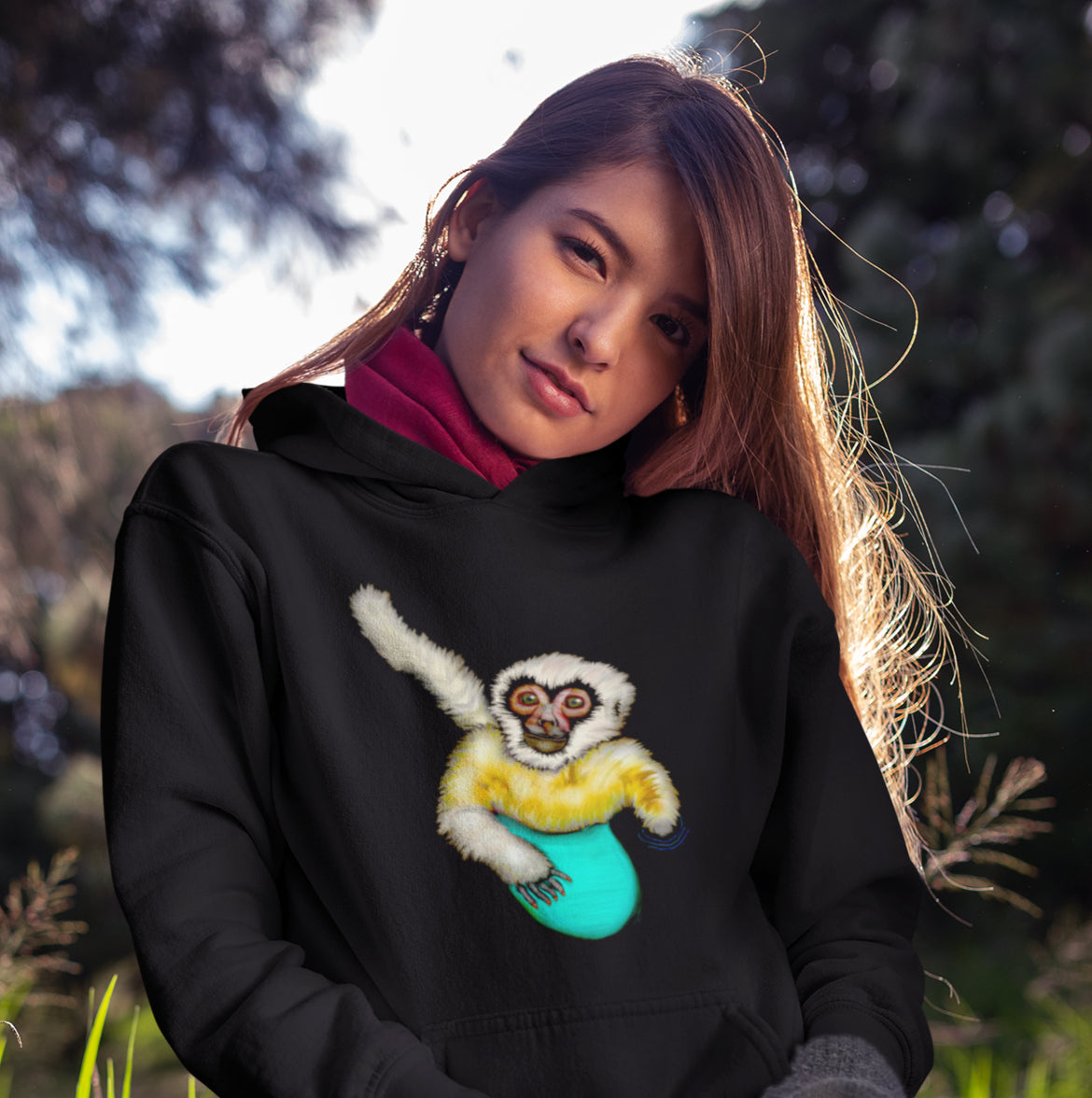 Woman wearing a surfing white cheeked gibbon sustainable vegan hoodie