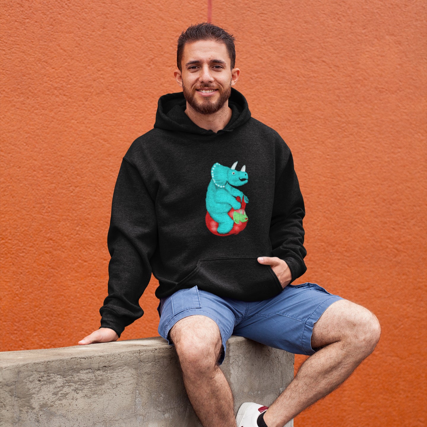 Man wearing a Triceratops on a space hopper sustainable vegan hoodie